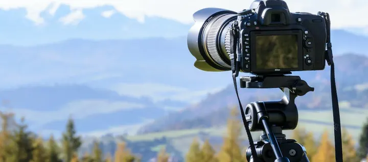 Kamera auf einem Stativ vor einer Berglandschaft